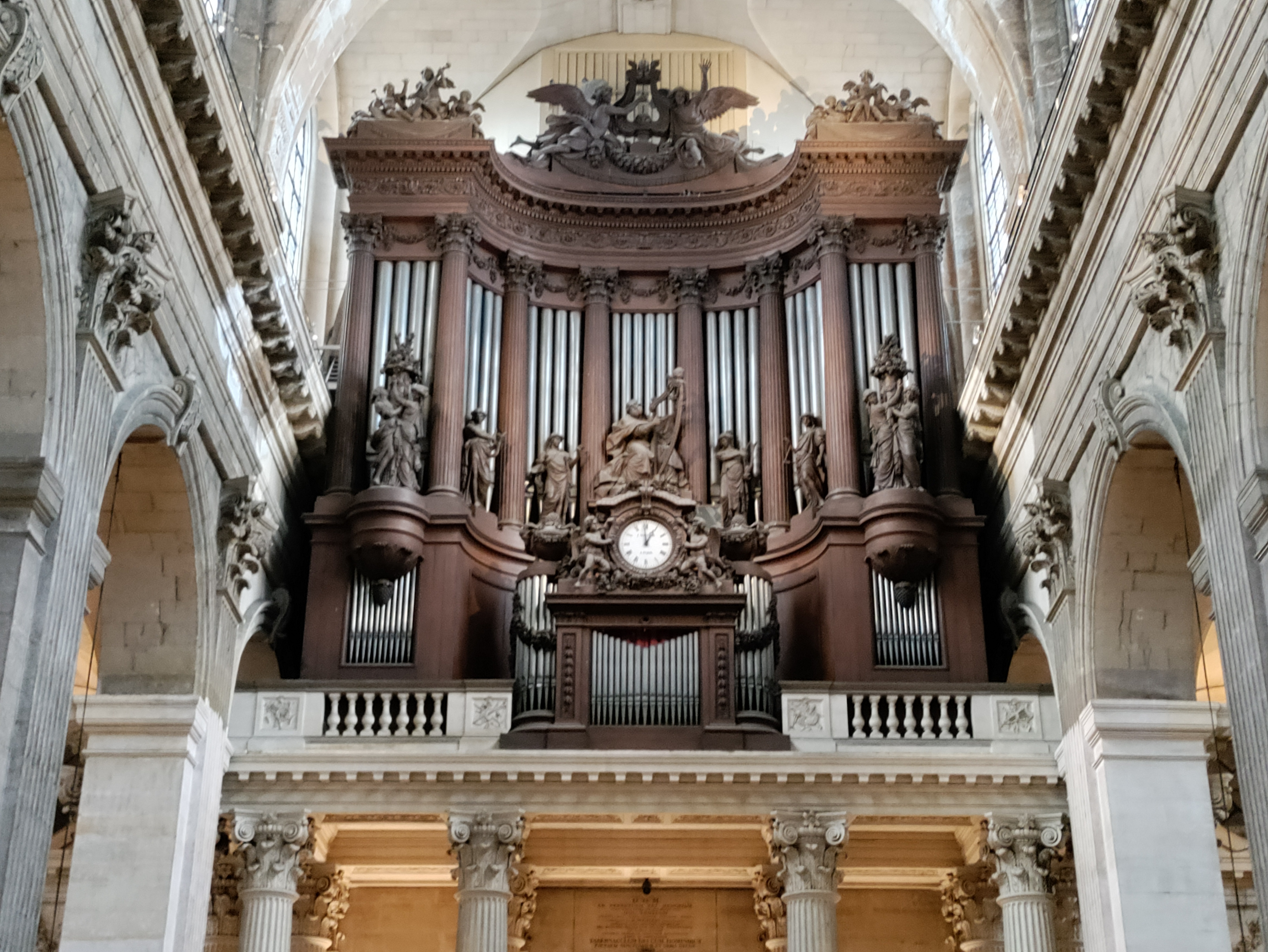 Famous organ inside the Church of Saint Sulpice with a broken clock.